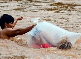 Crianças de uma vila no Vietnã atravessam rio de águas bravas em sacos plásticos para chegar à escola