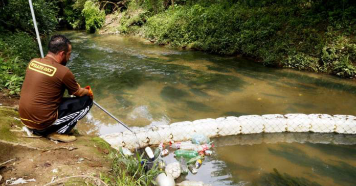 Brasileiro cria sozinho uma ecobarreira para limpar rio que passa ao lado da sua casa