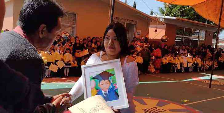asomadetodosafetos.com - Mãe carrega foto de seu filho falecido para receber o diploma do garoto no jardim de infância